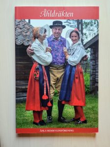 bokomsalg foto en man och två kvinnor i Åhldräkt